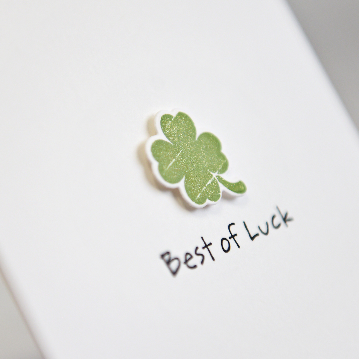 green four leaf clover on handcrafted greeting card